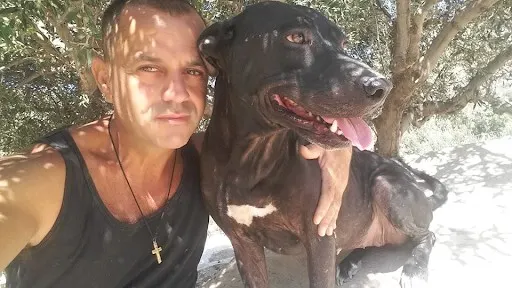 Theoklitos Proestakis in photo with arm around a dog